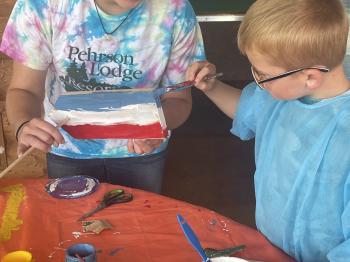 Staff assist children with their model sailboats.