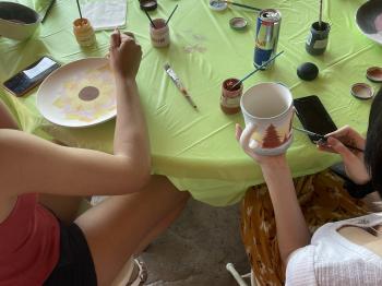 A family glazing ceramics with a lake view.