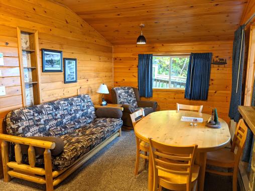 Living room with a futon, chair and dining room table.