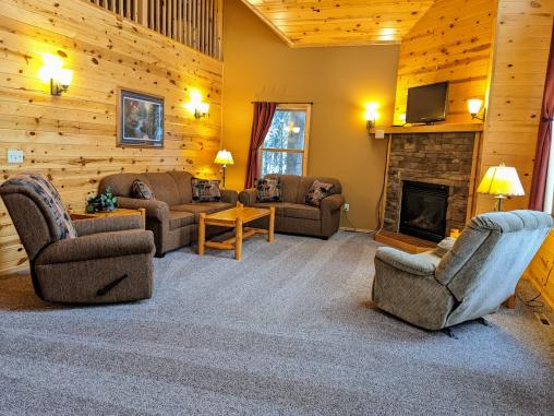 Spacious living room with couch, love seat, two recliners, gas fireplace, TV, and satellite programming.