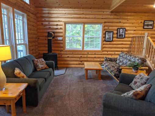 Spacious living room with a couch, loveseat, futon and gas fireplace.