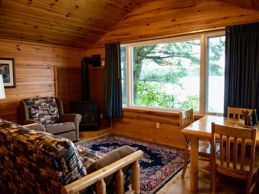 Living room with futon, dining table, gas fireplace and lakeside views of Vermilion.