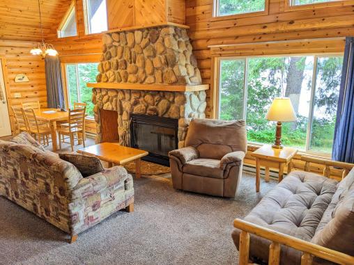 Spacious living room with a couch, futon, recliner, and wood burning fireplace.