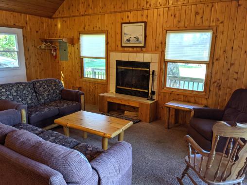 Living room with a couch, love seat, recliner, rocking chair, and patio doors leading to the deck.