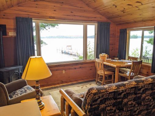 Living room with a futon, chair, gas fireplace, dining table, and views of the lake.