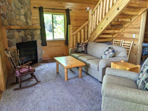 Living room with a couch, chair, and wood burning fireplace.