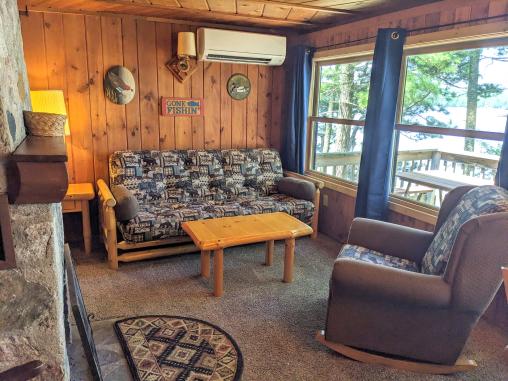 Living room with a double futon, rocking chair, wood burning fireplace and views of Lake Vermilion