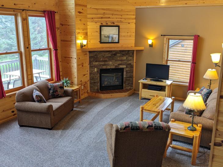 Living room with ample furniture, gas fireplace, TV, and satellite programming.