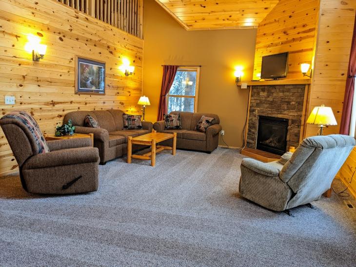 Spacious living room with couch, love seat, two recliners, gas fireplace, TV, and satellite programming.