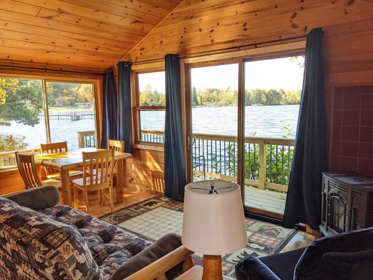 Living and dining room with gas fireplace and patio doors opening up to Lake Vermilion