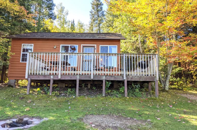 Lakeview cabin's exterior with driveway and firepit. 