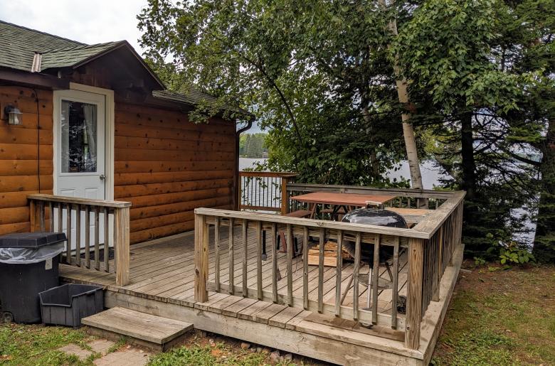 Sunbeam's entrance with deck, picnic table, and charcoal grill.