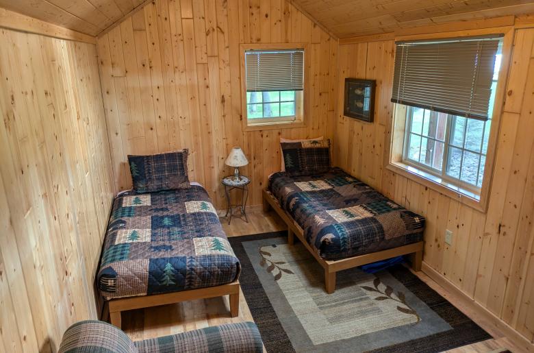 Bunk house with two twin beds, couch, and no plumbing.