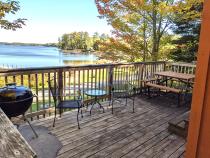 Deck area with a picnic table, charcoal grill, and overlooks the beach.
