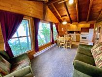 Lakeside facing living area with couch, chair, and kitchen table.