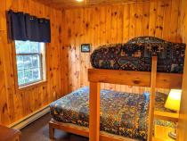 Bedroom with a full size bed and a twin lofted above it.