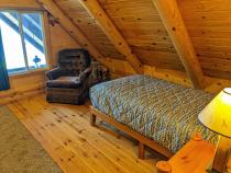 Loft bedroom with a twin and chair.